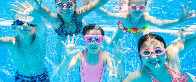 Children playing underwater in pool at Queens Beach Tourist Village.